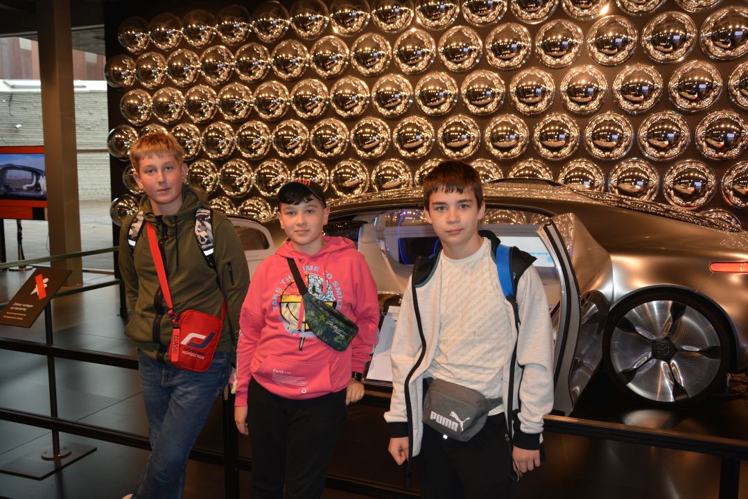 Trzej chłopcy na tle samochodu ekspozycyjnego w Centrum Nauki Kopernik w Warszawie