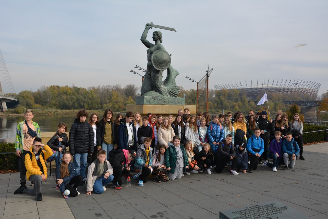 Uczestnicy wycieczki przed Pomnikiem Syreny w Warszawie