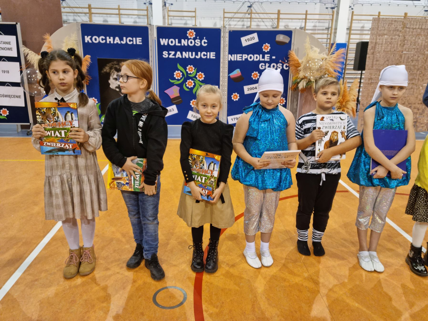 Grupa małych uczniów z nagrodami książkowymi