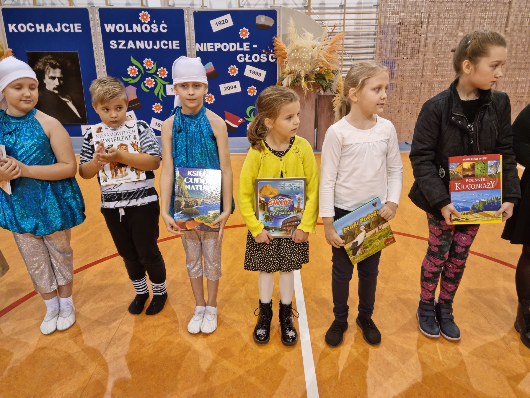 Grupa małych uczniów z nagrodami książkowymi