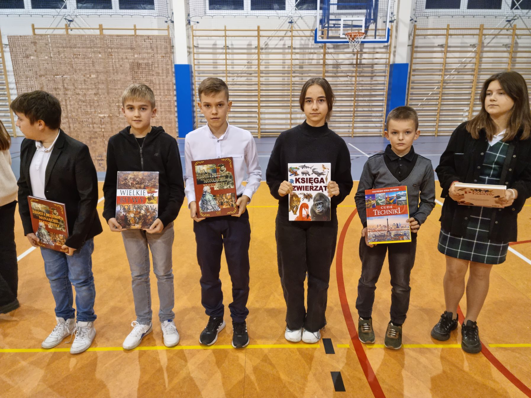 Grupa uczniów z nagrodami książkowymi