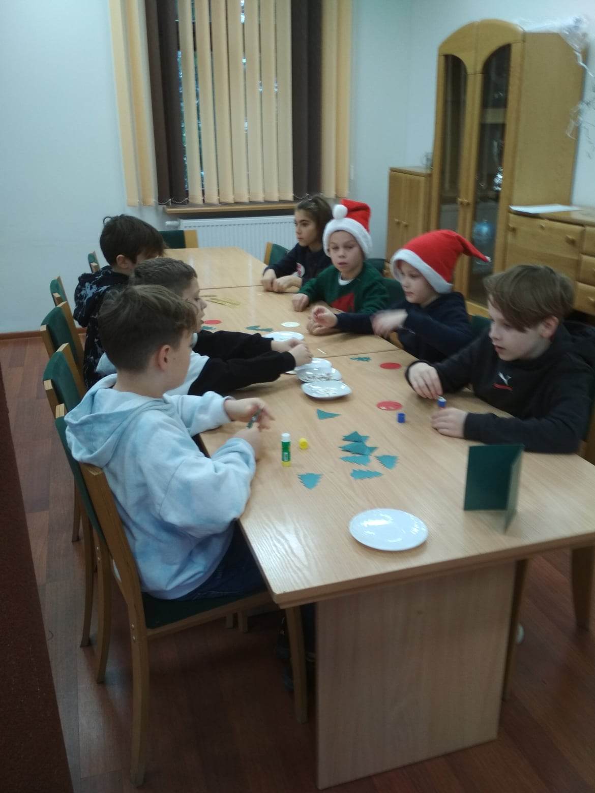 Grupa chłopców wykonująca ozdoby na kartki świąteczne