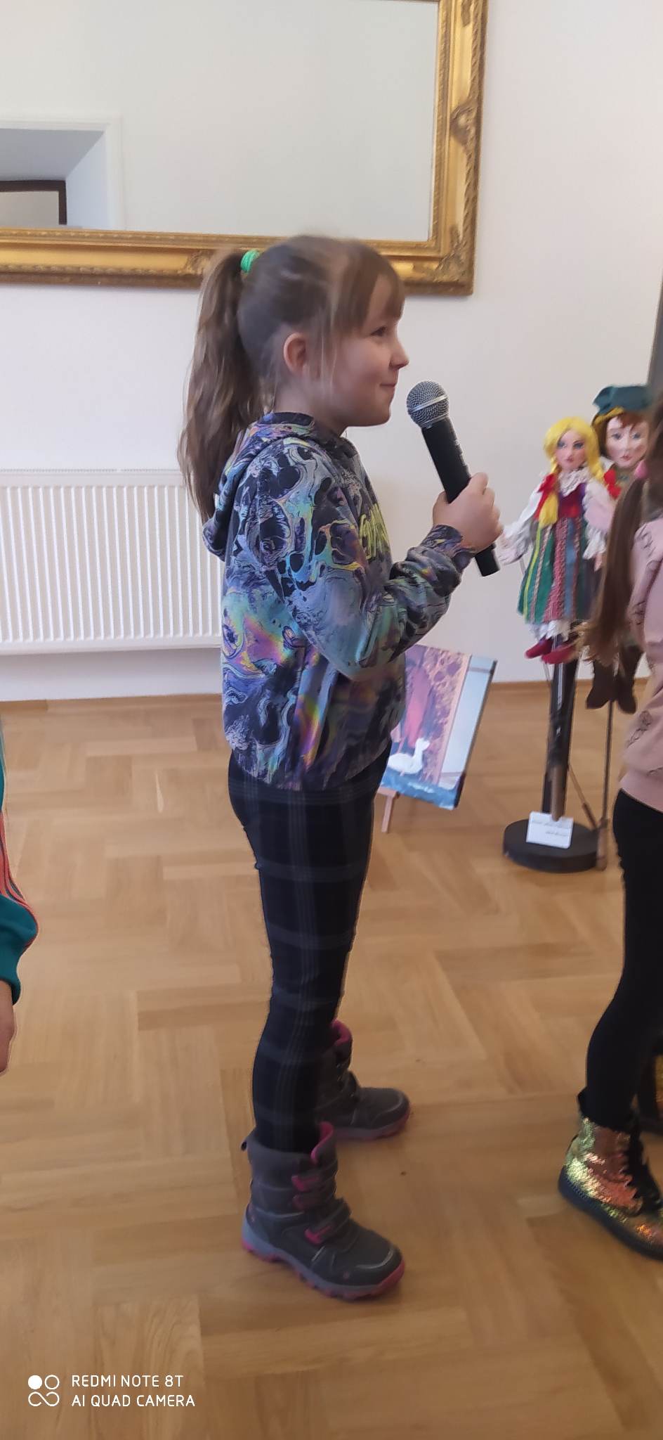 Dziewczynka stoi z mikrofonem