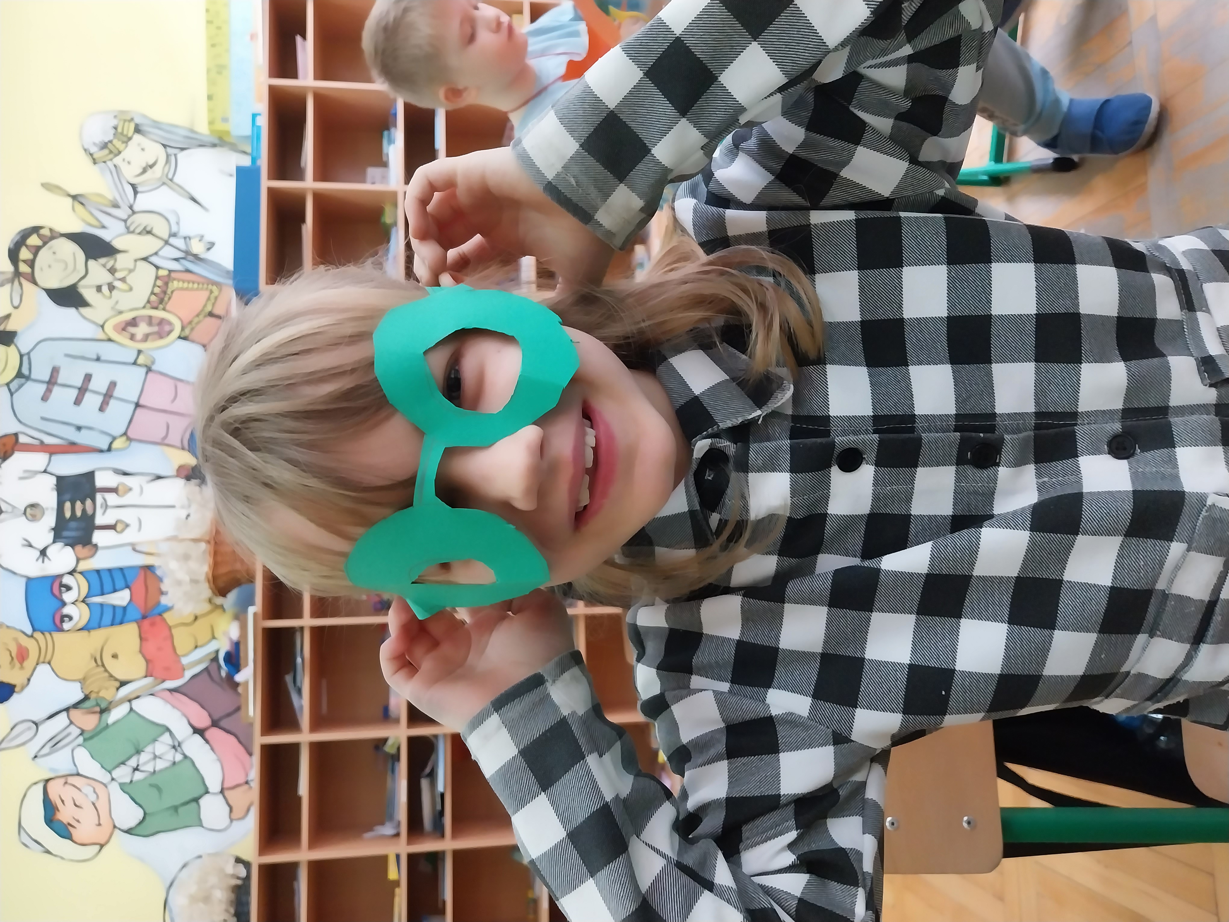 Dziewczynka w zielonych okularach z papieru