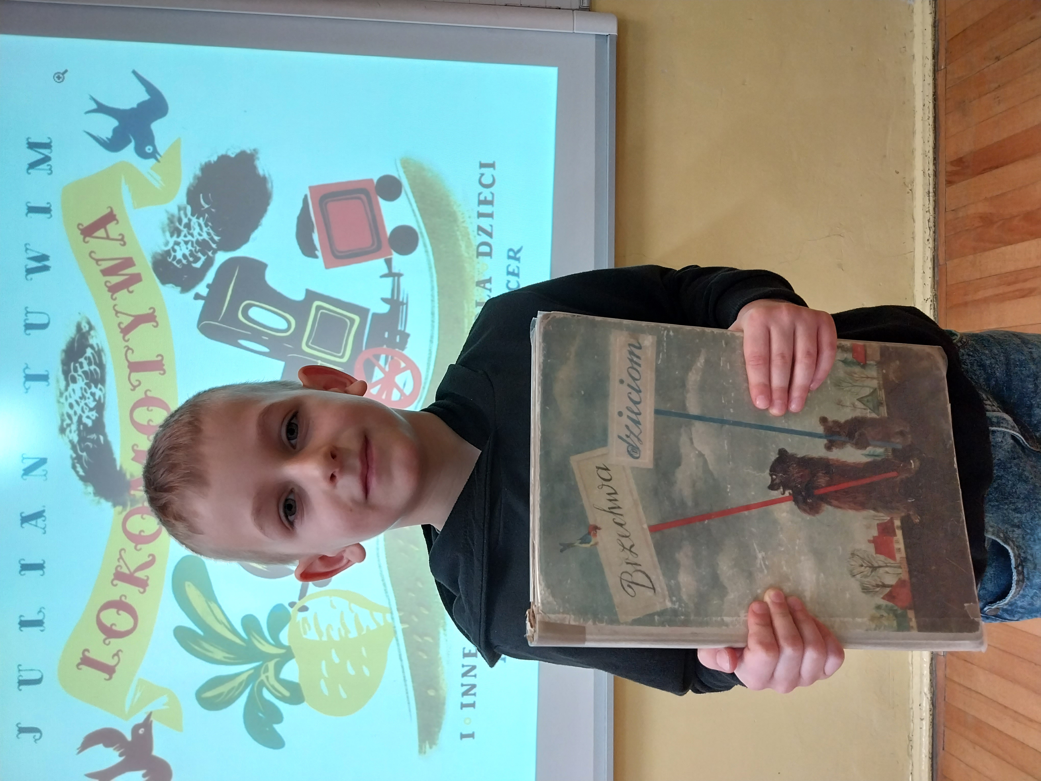 Chłopiec ze starą książką Brzechwa dzieciom