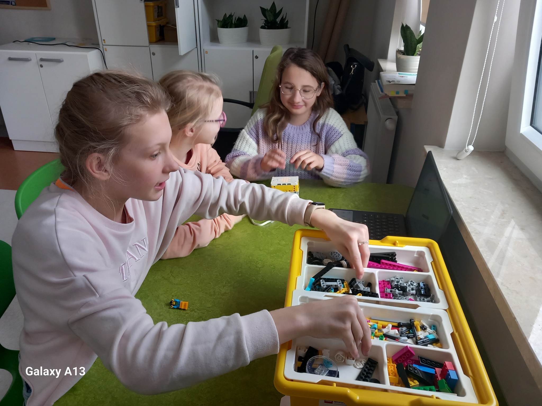 Trzy dziewczynki budują z klocków