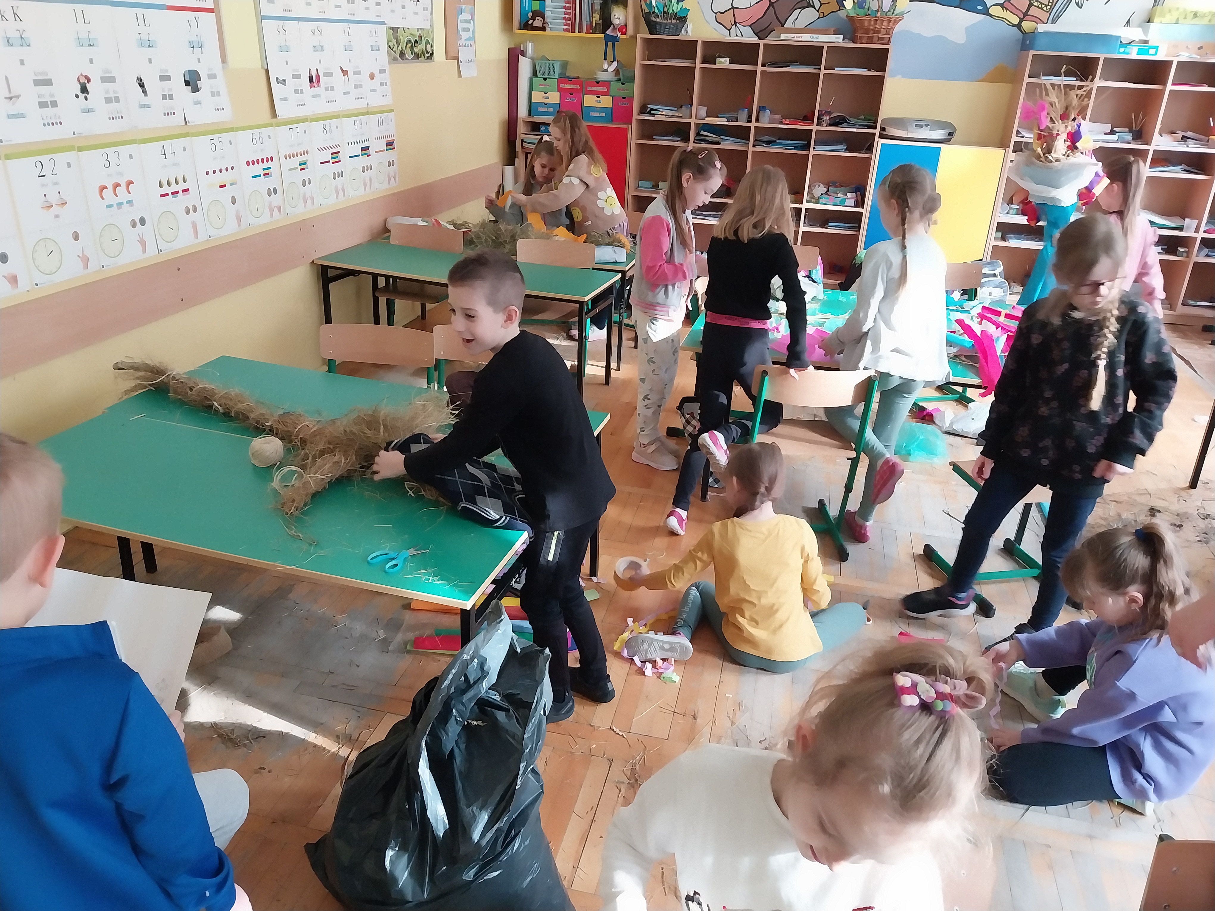 Dzieci w sali lekcyjnej wykonują marzannę