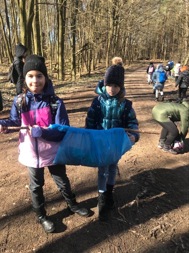 Dziewczynki uczestniczą w sprzątaniu lasu