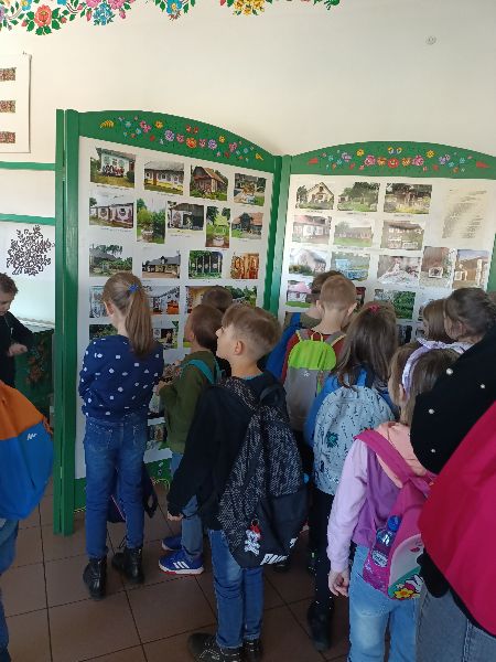 Dzieci oglądają zdjęcia zdobionych chat w Zalipiu