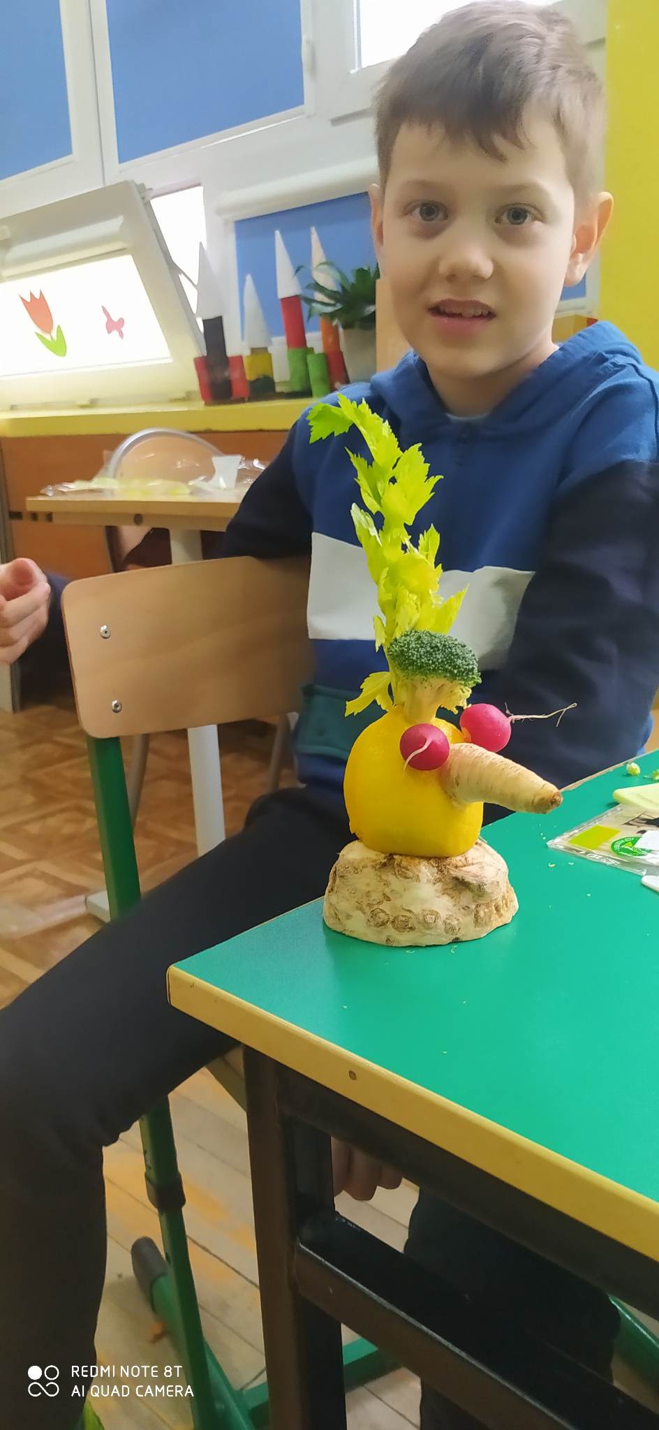 Chłopiec siedzi przy stworku z warzyw