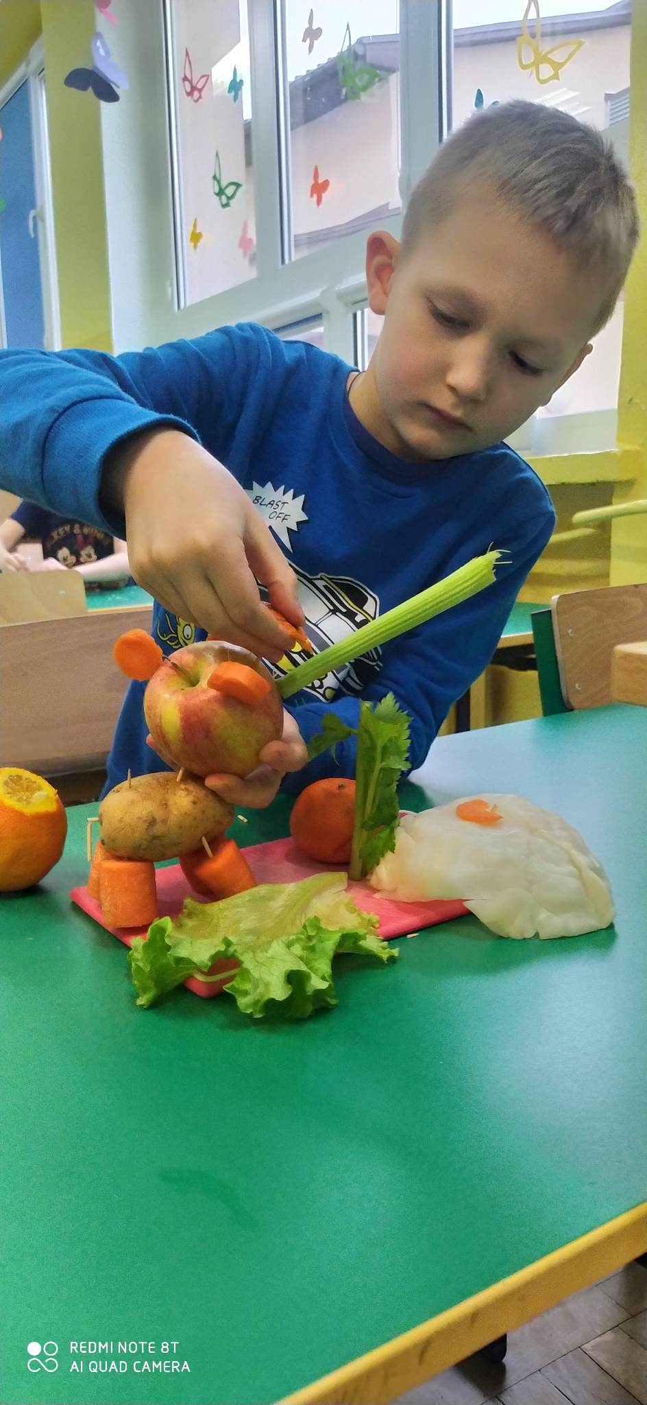 Chłopiec wykonuje stworka z warzyw