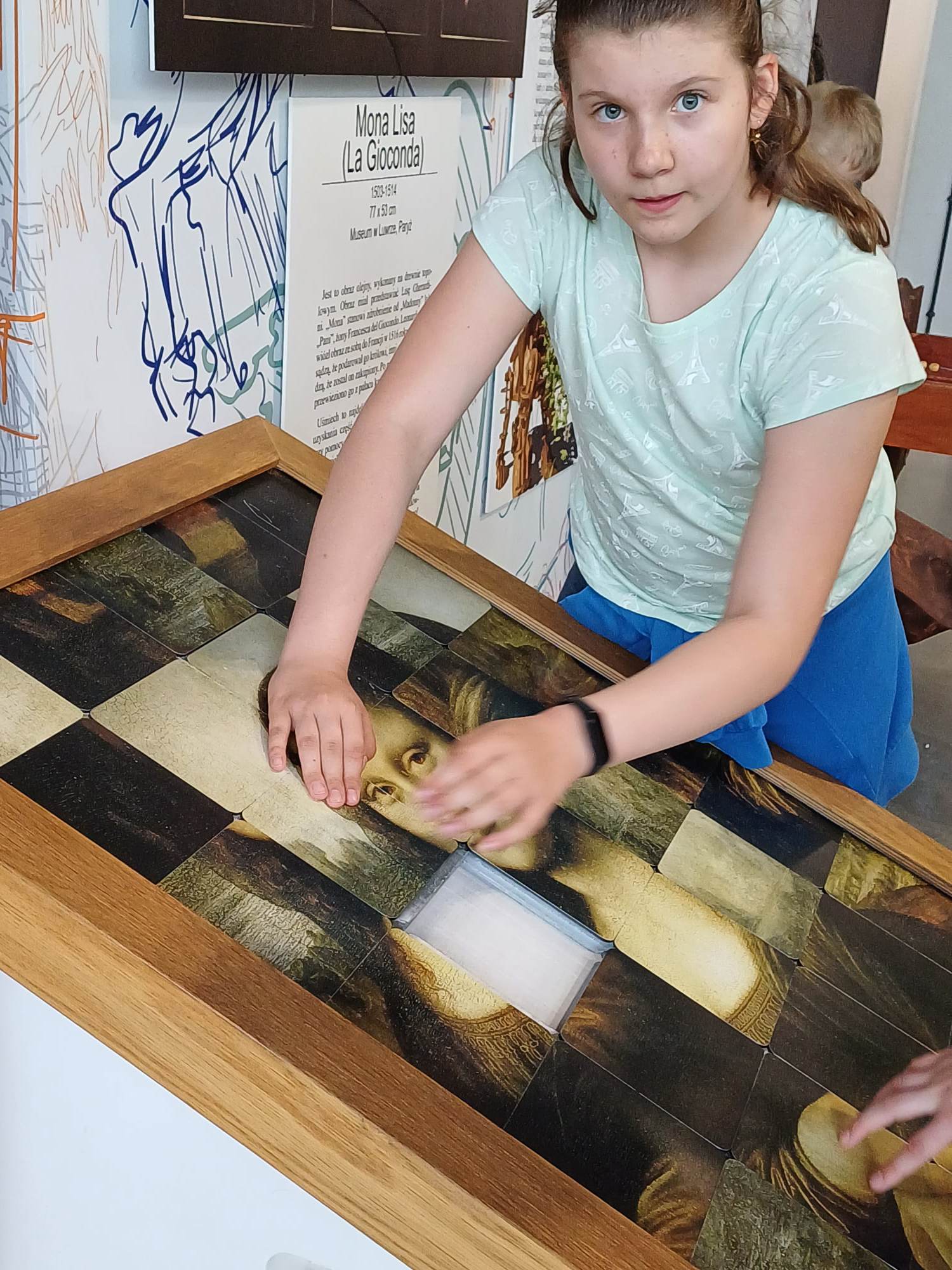 Dziewczynka układa puzzle Mona Lisa